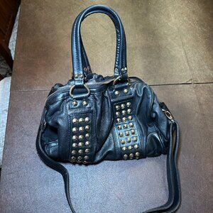 Black vegan leather satchel with top handles, gold rivets, and shoulder strap